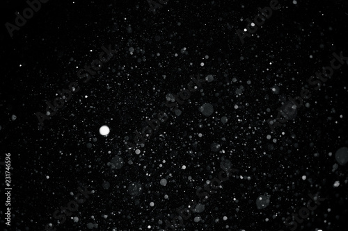 Falling snow on black background.