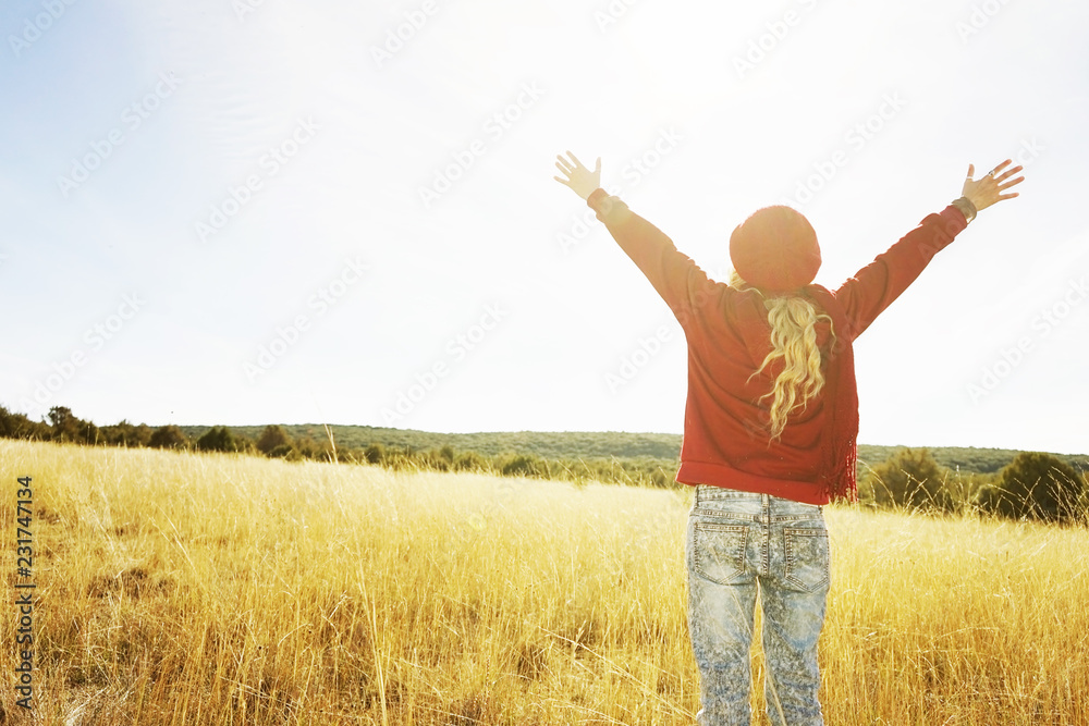 Back view of a young woman in nature in a sunny autumn day Back view of a young woman in nature in a sunny autumn day