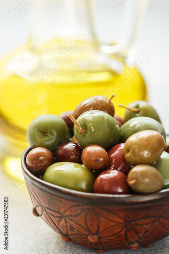 Mixed marinated olives (green, black and purple) in ceramic bowl  and olive oil
