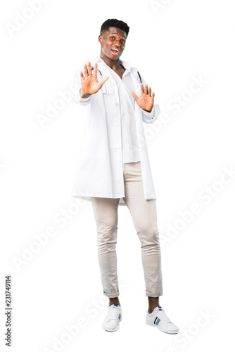 Full body of African american doctor is a little bit nervous and scared stretching hands to the front on white background