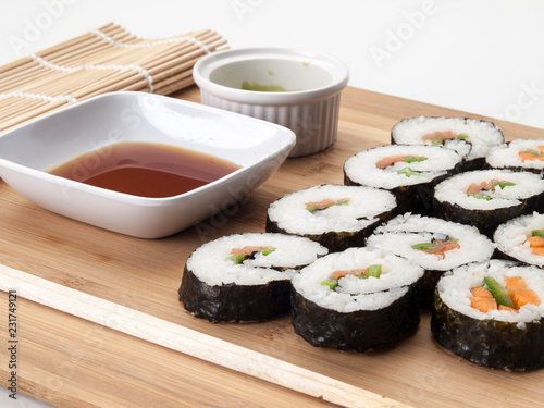 Bandeja con resultados de sushi sobre una tabla de cocina yun fondo blanco