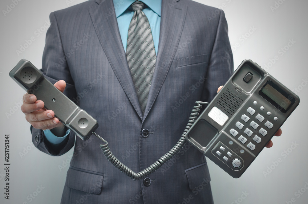 Telephone and phone handset in the businessman hands isolated on the white background. Telephone and phone handset in the businessman hands isolated on the white background.