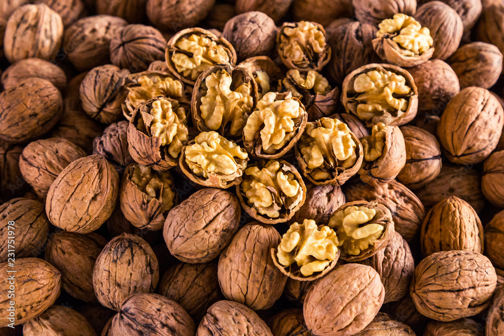 Many walnuts lie on the market and in the store. Open and peeled nuts are full of vitamins, a fresh and healthy snack for vegetarians. Shelled nuts in curved forms. Big plates on the market. Many walnuts lie on the market and in the store. Open and peeled nuts are full of vitamins, a fresh and healthy snack for vegetarians. Shelled nuts in curved forms. Big plates on the market.