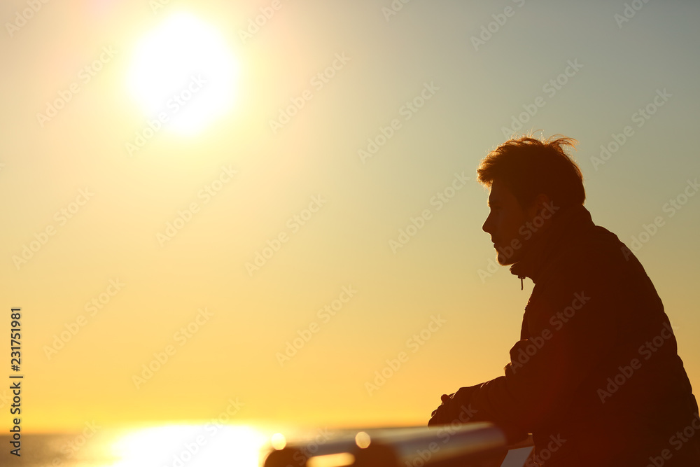Man silhouette contemplating sunset