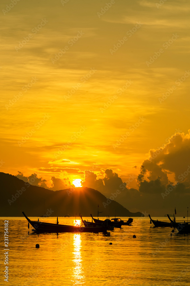 Boat sailing along its journey against a vivid colorful sunset.