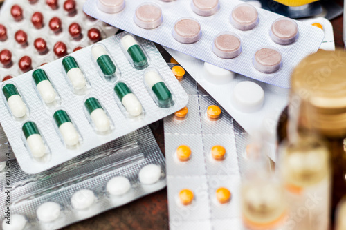 Medicines and bottle on wooden table 