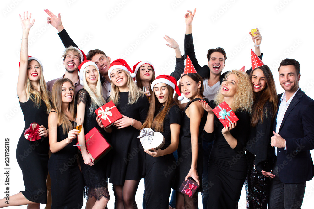 Group of young beautiful people in stylish black clothes and santa hat with gift boxes in hands having fun.
