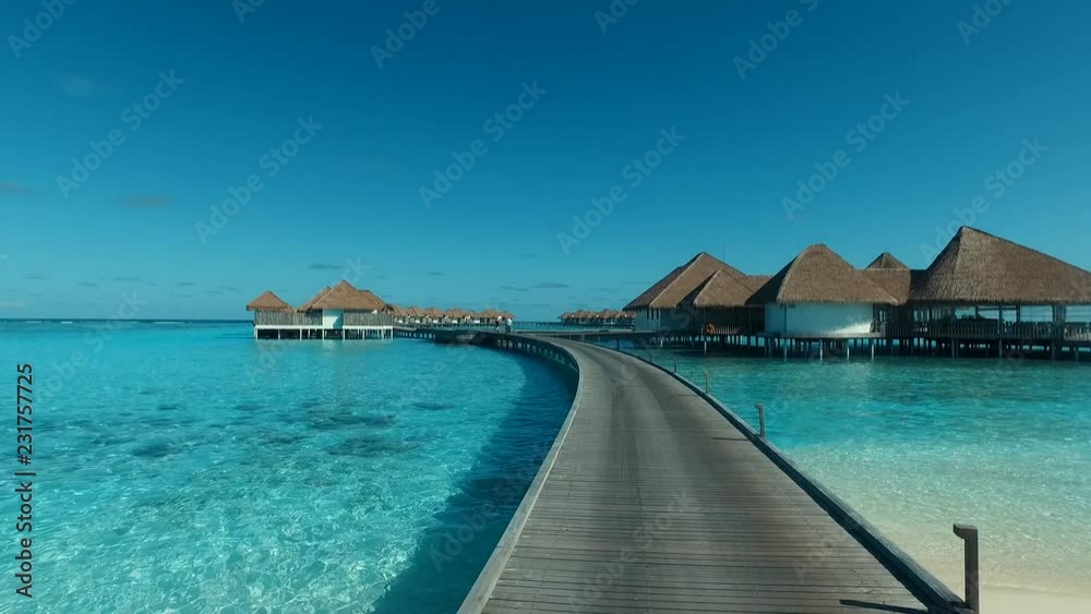 Crossing walkway to overwater villa in the Maldives