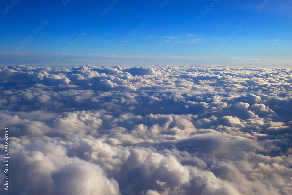Fototapeta premium over cumulus clouds bright landscape view from the window of an airplane