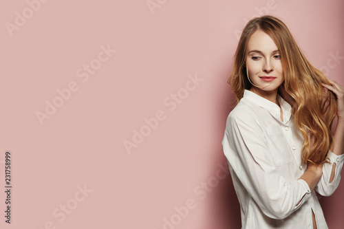 Pretty young woman posing on pink background