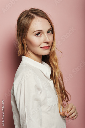 Pretty young woman posing on pink background