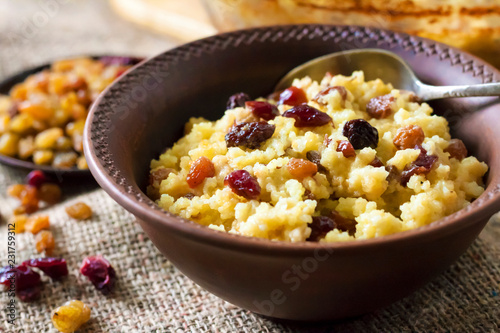 Sweet millet porridge with raisins and dried cranberries photo