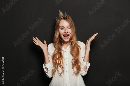 Close up portrait of adorable girl with golden crown holding han