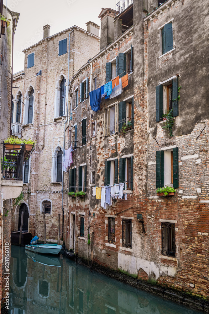 Kanal mit Häusern und draußen hängender Kleidung in Venedig