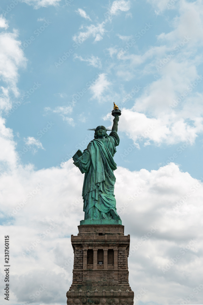 Obraz premium New York City / USA - AUG 22 2018: The statue of liberty back view in clear blue sky