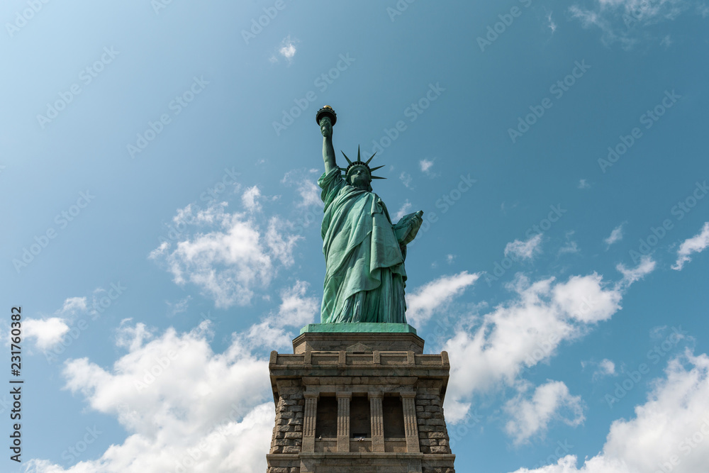 Fototapeta premium New York City / USA - AUG 22 2018: The statue of liberty back view in clear blue sky