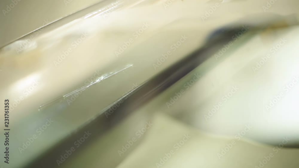Close-up of a man professionally in the workshop engaged in eliminating cracks on the windshield of the car. Crack overview Close-up of a man professionally in the workshop engaged in eliminating cracks on the windshield of the car. Crack overview