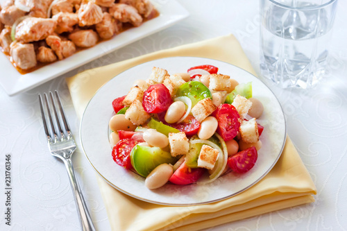 Salad with three kinds of tomatoes, boiled white kidney beans and croutons from white bread