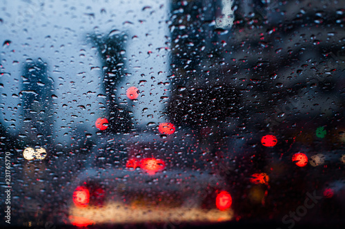 wet car windshield during rainy weather blured traffic light