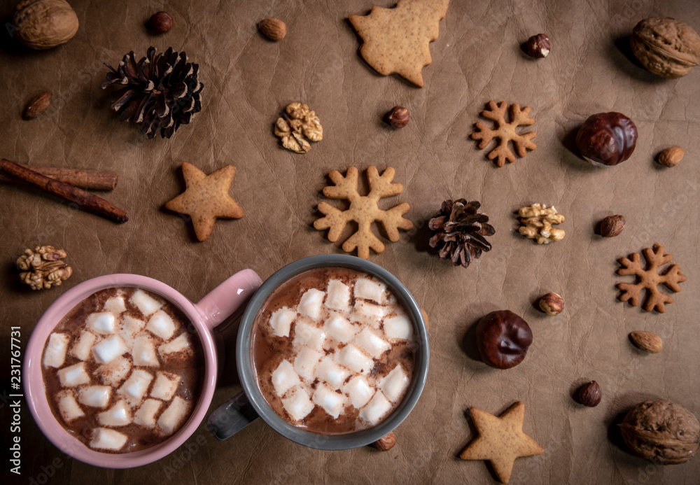 Two cups of hot chocolate with marshmallows on a brown tablecloth