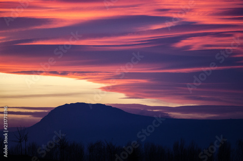Fototapeta Naklejka Na Ścianę i Meble -  Fluffy orange and purple clouds over the mountain
