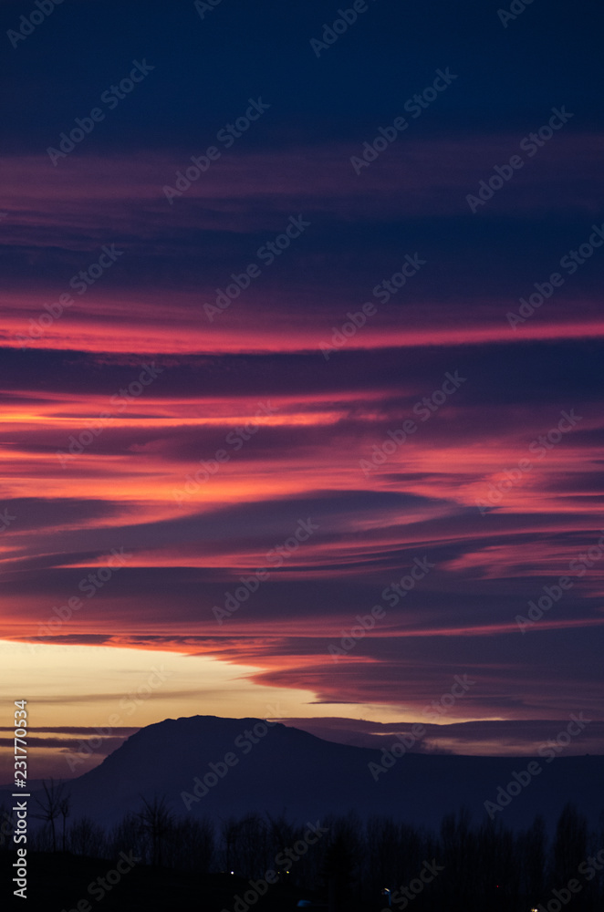 Fluffy orange and purple clouds over the mountain