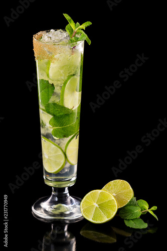 Closeup glass of fresh mojito cocktail with mint and lime isolated at black background.
