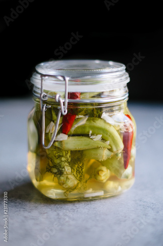 Okra pickles with peppers in glass jar