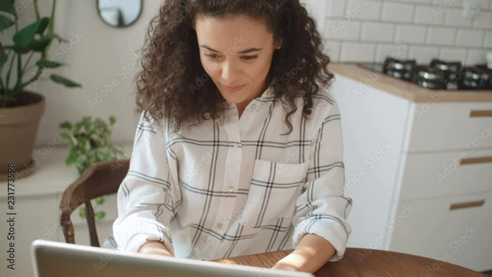 Charming young woman typing on laptop computer at home. Charming young woman typing on laptop computer at home.