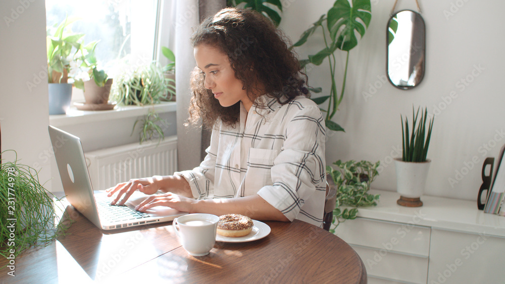 Charming young woman typing on laptop computer at home. Charming young woman typing on laptop computer at home.