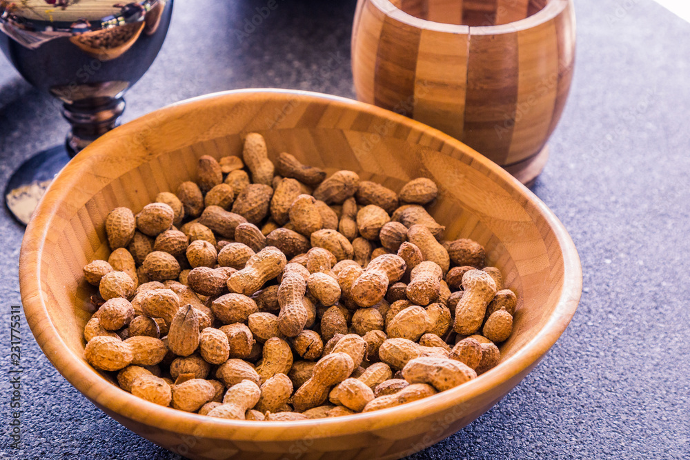 A lot of peanuts are a tasty and fresh snack. Natural and healthy nuts are full of vitamins and oils. They lie in a wooden bowl in the store and on the market. A lot of peanuts are a tasty and fresh snack. Natural and healthy nuts are full of vitamins and oils. They lie in a wooden bowl in the store and on the market.