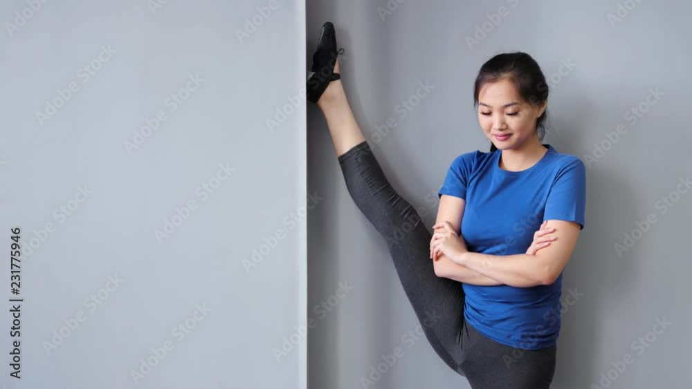 Smiling Asian professional ballet dancer or pilates woman showing amazing stretching Smiling Asian professional ballet dancer or pilates woman showing amazing stretching