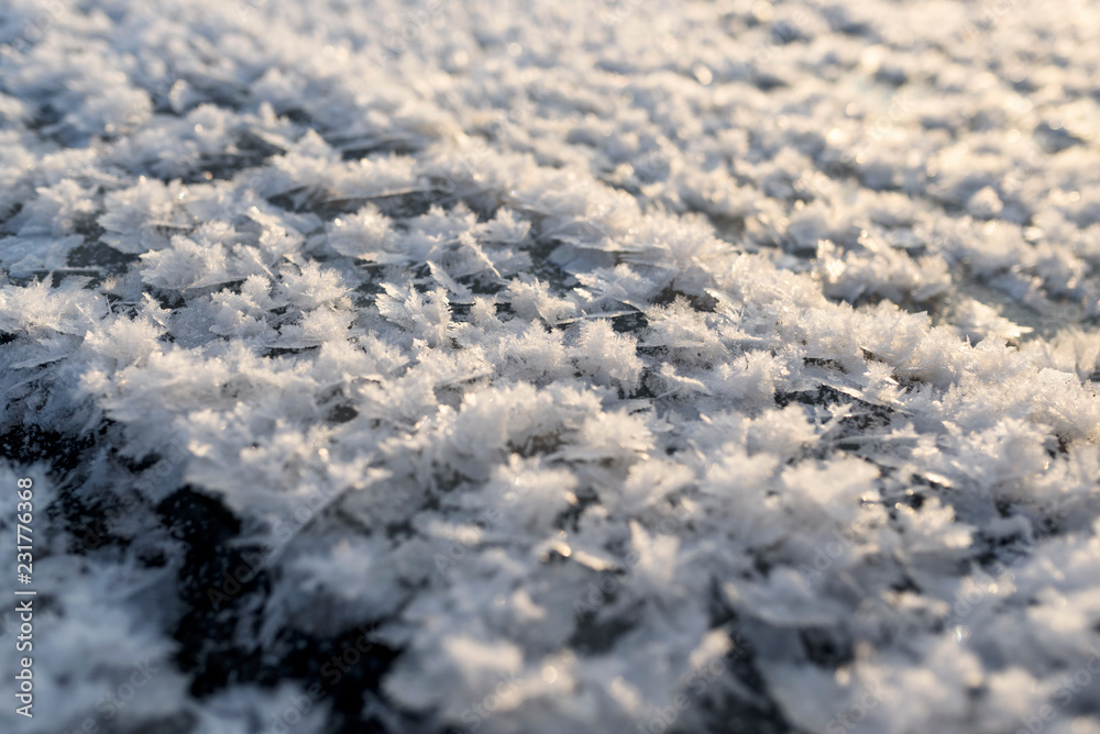 Frozen snowflakes on ice creates a beautiful texture. Amazing winter nature background.
