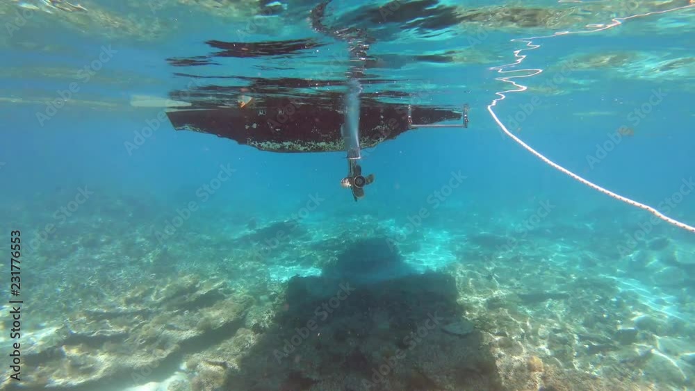 Coque de bateau et l'hélice de son moteur vus en plongée sous-marine