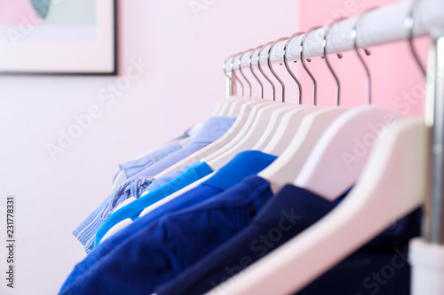 Bright clothes hanging on rack in room