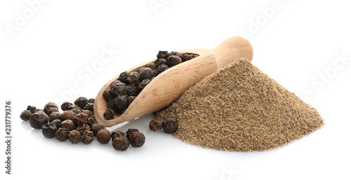 Wooden scoop with black pepper grains and heap of powder on white background
