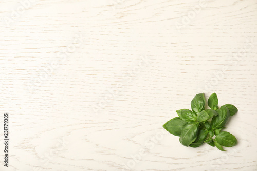 Fresh basil leaves on wooden background, top view. Space for text