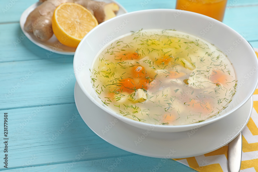 Bowl of fresh homemade soup to cure flu on wooden table