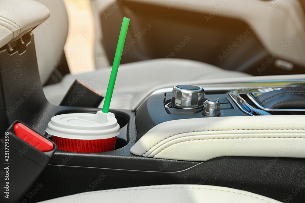 Takeaway paper coffee cup in holder inside car Takeaway paper coffee cup in holder inside car