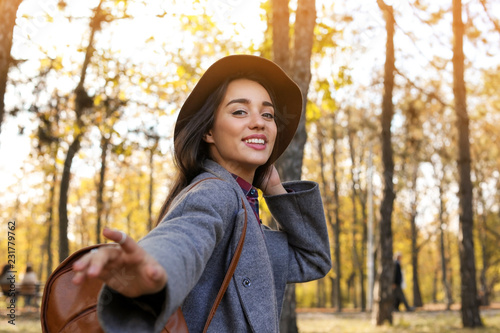 Young beautiful woman with backpack in park. Autumn walk