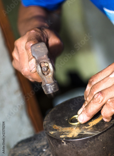 The process of making gold jewellery. Hammering the gold ring. Crafting a gold ring.