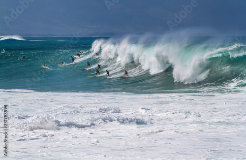 Fototapeta Naklejka Na Ścianę i Meble -  Surfers catching a wave in Hawaii