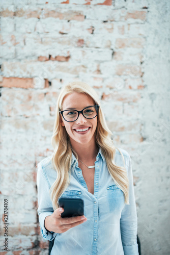 Portrait of a gorgeous smiling blonde woman with eyeglasses. Looking at camera.
