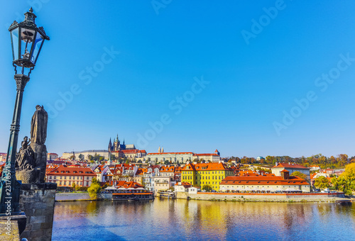 City view from bridge and traditional Czech architecture of antique Prague buildings at autumn evening.