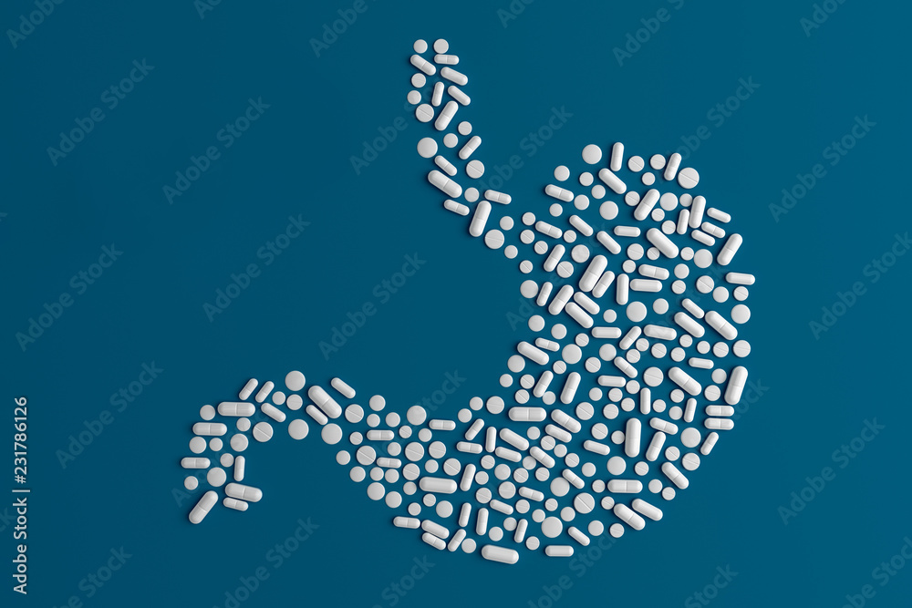Many pills scattered on a blue uniform background in the form of a silhouette of the human stomach 3d illustration