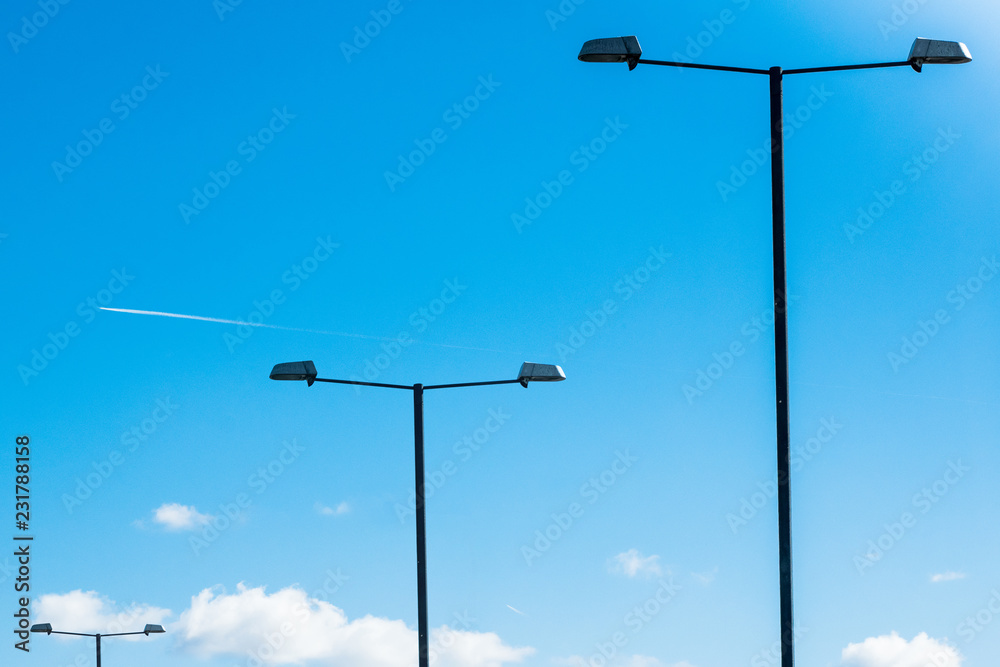 Some Street light post bulb in order against beautiful clear blue cloudy sky Some Street light post bulb in order against beautiful clear blue cloudy sky
