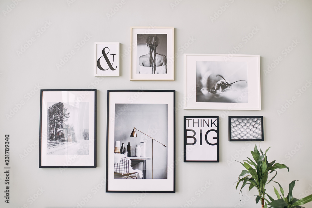 different size framed photos hanging on the gray wall. - obrazy, fototapety, plakaty 
