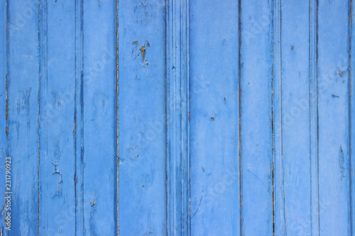 Old historical blue painted wooden door vertical lines detail markings cracks