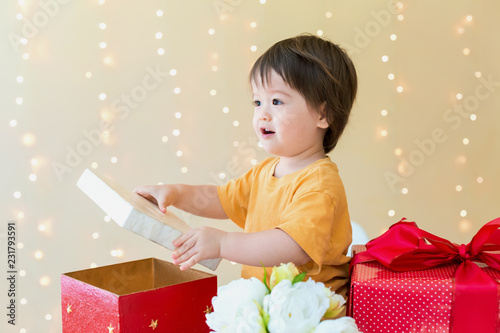 Happy toddler boy with Christmas present boxes