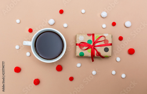 Christmas gift box with coffee cup on a light brown paper background